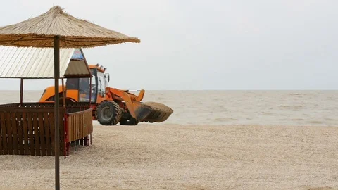 Orange tractor in the background of grey sea Stock Footage 98261710