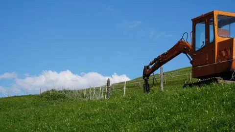 Orange tractor. Blue Sky. In Switzerland Stock Photos