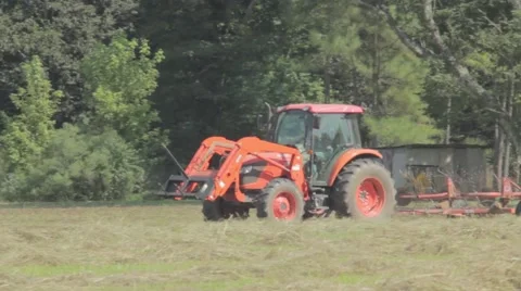 Orange tractor driving about in field Stock Footage 42105448