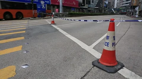 Orange traffic cone on the side of the road and people on pedestrian crossing Stock Footage 44410728