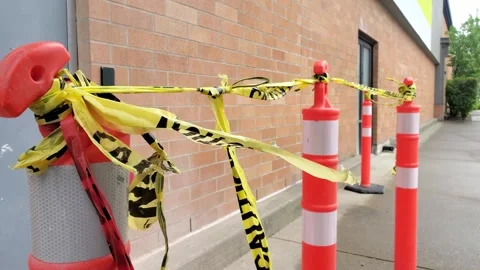 Orange traffic delineator posts with yellow caution tape blocking sidewalk path Stock Footage 341967566