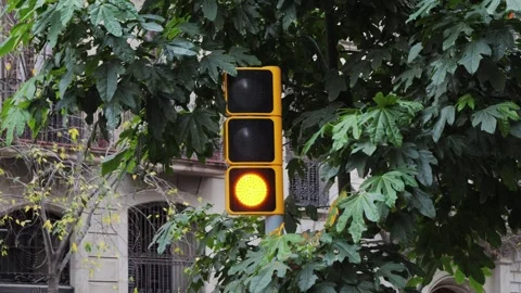 An orange traffic light flashing on a large city road. Modern technologies for Stock Footage 303894445