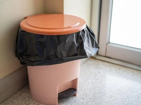 Orange trash is located in the corner of the room. Stock Photos