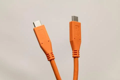 Orange USB-C to USB-A cable connectors isolated against neutral background Stock Photos