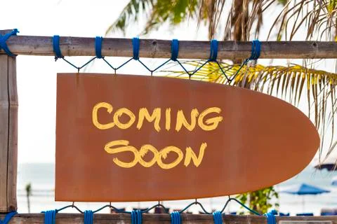 Orange vintage signboard in shape of surfboard with Coming Soon text and palm Stockfoto's