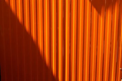 The orange wall has a shadow on it Stock Photos