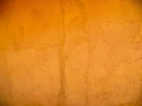 Orange wall with rustic texture made with mortar and some cracks Foto stock