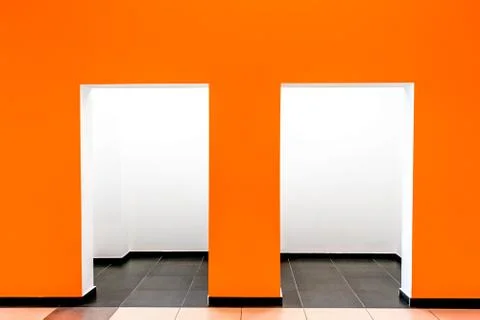 A orange wall with two openings inide the building. Stock Photos