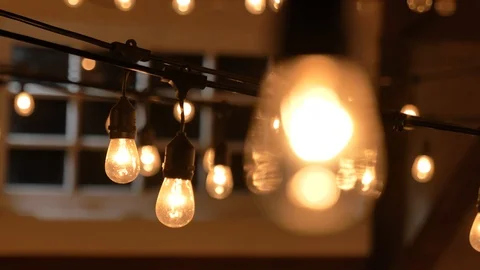 Orange warm lightbulb close up rack focus from lights in background Video stock 120303946