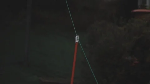 Orange washing line pole blowing in the stormy wind with a green garden Stock Footage 101761747