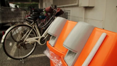 Orange Waste Bins in Front of Parked Bicycles in Urayasu Japan Stock Footage 321134050