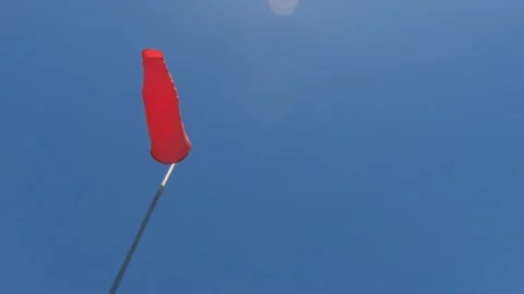 Orange Windsock Anemometer fluttering against blue sky background Video stock 320102155