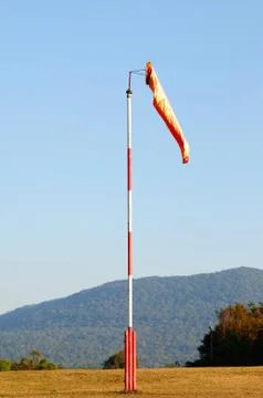 An Orange Windsock or Windvane on a Red and White Pole Stock Photos