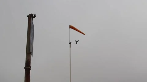 Orange Windsock On Pole With Sign Post Overcast Sky Stock Footage 343414520