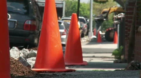 Orange work cones with jackhammer machine breaking sidewalk Stock Footage 11025878