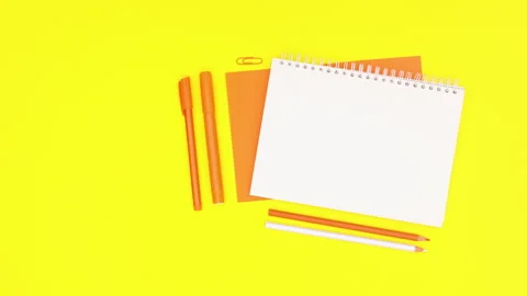 Orange working stationery and open notebook appear on yellow theme. Stop motion Stock Footage 136440449