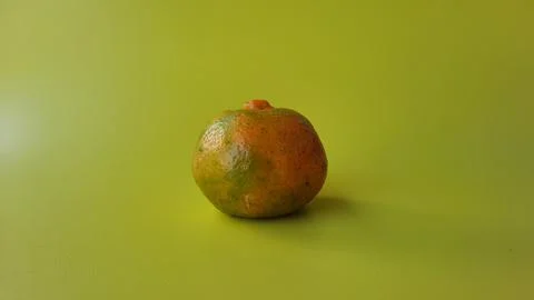 An orange on a yellow background Stock Photos