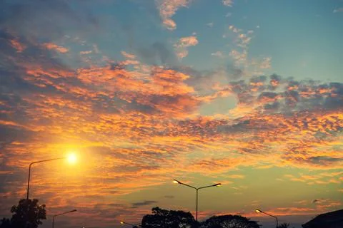 An orange-yellow cloud with a light pole on a street in Thailand. Stock Photos