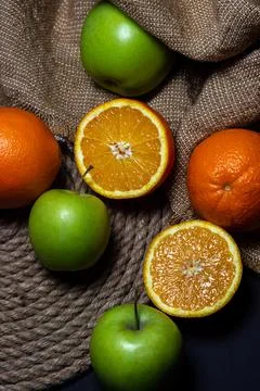 Oranges and apples on a dark background. freshly cut fruit.  Stock Photos