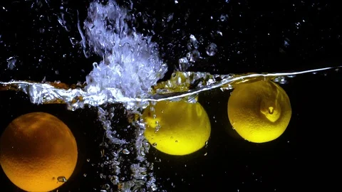 Oranges and Lemons Fall Into Water. Slow motion Video Stock Footage 100052172