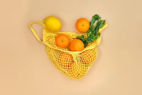 Oranges and lemons with mint branches in a string bag Stock Photos