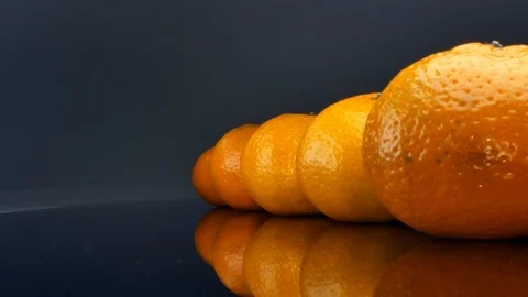 Oranges arranged in a row on a black background Stock Footage 125992557