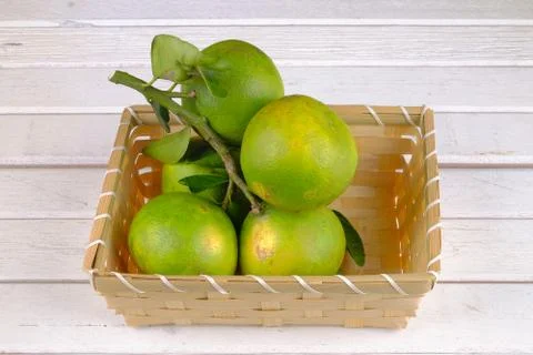 Oranges in a basket  on white table Stock Photos