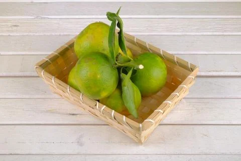 Oranges in a basket  on white table Stock Photos