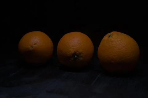 Oranges on a black surface Stock Photos