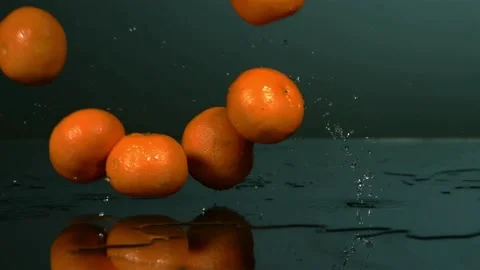 Oranges bounce on wet surface with splashes Stock Footage 326754170