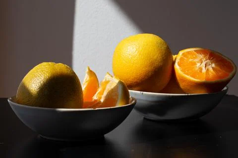 Oranges for breakfast. Healthy fruit in different plates on a black backgroun Stock-Fotos