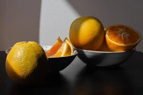 Oranges for breakfast. Healthy fruit in different plates on a black backgroun Foto stock