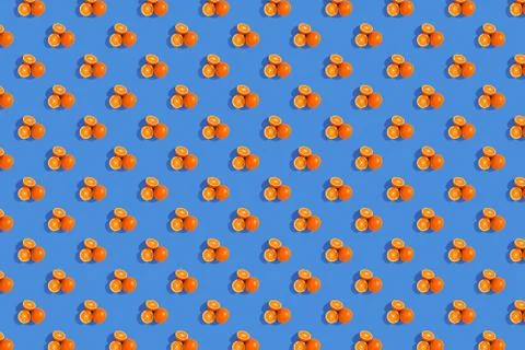 Oranges on a bright colored blue background. Repeating pattern, preparation f Stock Photos