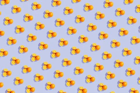Oranges on a bright colored blue background. Repeating pattern, preparation f Stock Photos