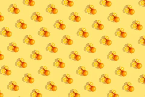 Oranges on bright colored yellow background. Repeating pattern, preparation f Stock Photos