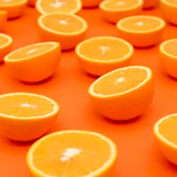 Oranges cut in half on an orange background. Side view. Stock Photos