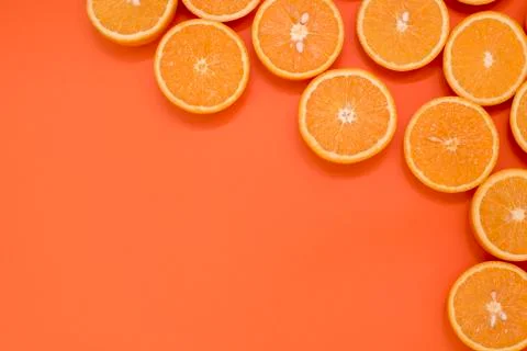 Oranges cut in half on an orange background in the corner of the photo Stock Photos