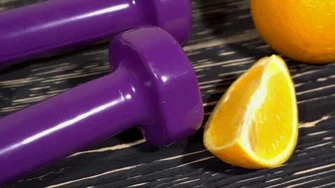 Oranges, dumbbells and measuring tape on wooden background. Stock Footage 70047514