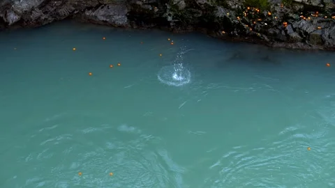 Oranges fall into the river during the orange battle at the Ivrea's Carnival. Stock Footage 306736895