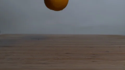Oranges falling and bouncing on the wooden surface Stock Footage 100005851