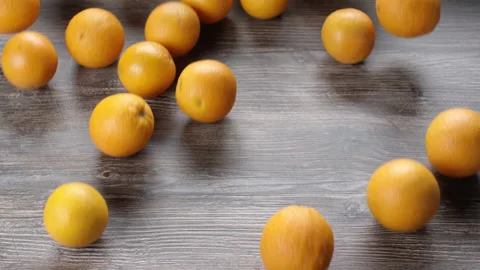 Oranges falling and rolling on a wooden table. Stock Footage 169818096