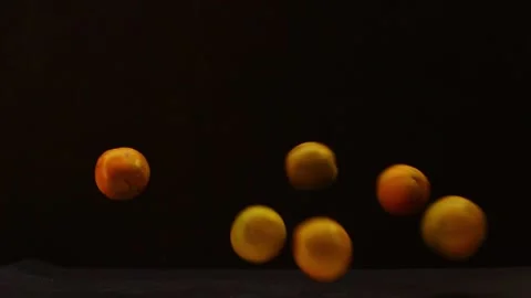 Oranges falling in group on a black background Stock Footage 131250977