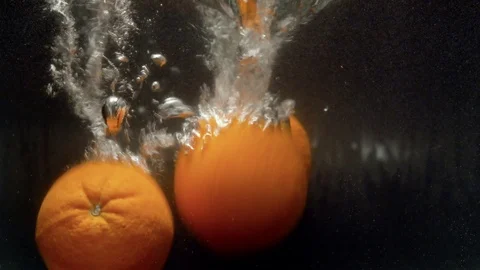 Oranges falling into the water Stock Footage 123704725