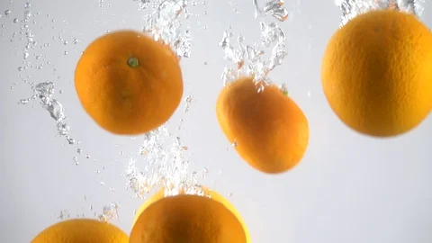 Oranges falling into the water. Slow motion 動画素材 128071127