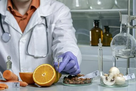 Oranges on a laboratory table with the name of vitamin. Essential vitamins. D Stock Photos