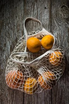 Oranges in a mesh bag. Stock Photos