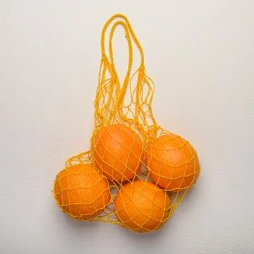 Oranges in a mesh string bag made of natural material. Environmental protection Stock Photos