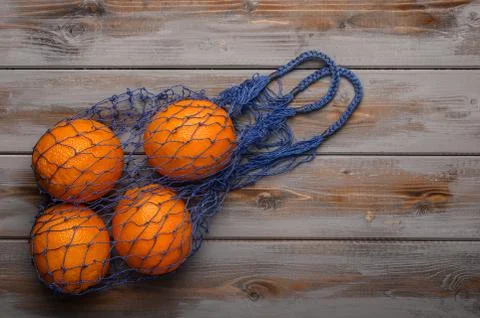 Oranges in a mesh string bag made of natural material. Environmental protection Stock Photos