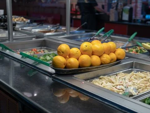 Oranges piled on a buffet table with various pastas Stock Photos