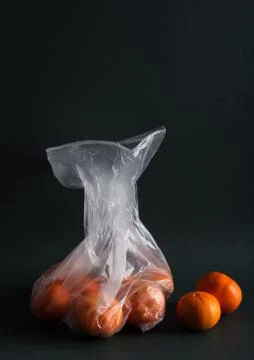 Oranges in plastic bag on a black background Stock Photos